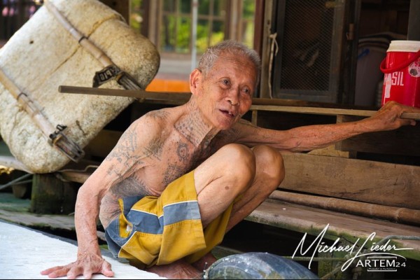 Thailand Mae Klong - Tätowierter Mann vom schwimmenden Markt